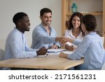 Small photo of Diverse millennial ambitious business partners coming to agreement, handshake accomplish negotiations at group meeting, establishing partnership, make deal feeling satisfied. Succeed result concept