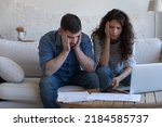 Small photo of Concerned upset millennial couple counting overspent budget, doing paperwork, thinking on financial problems, high mortgage, rental fees, bad loan conditions, bankruptcy, eviction notice