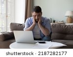 Small photo of Millennial man counted income and expenses looks upset because of lack of funds for monthly mortgage payments feels desperate sit near heap of bills feels stressed. Financial failure, debts concept