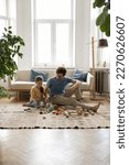 Small photo of Happy young dad and preschooler kid girl playing on floor at home, constructing toy tower from wooden building blocks, training creative talent, imagination, enjoying leisure, learning game