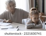 Small photo of Upbringing difficulties. Old lady teacher look with reproach at disobedient pupil girl turning away refusing to study. Annoyed older grandma talk to obstinate grandchild try to convince she is wrong
