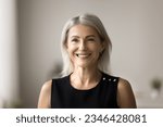 Small photo of Positive attractive blonde senior woman posing for shooting with perfect toothy smile, standing at camera, laughing. Happy pretty elder retired lady in black cloth head shot video call portrait
