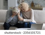 Small photo of Sad unhappy senior couple going through crisis, problem, bad news, eviction notice, medical checkup result. Mature wife giving support, empathy, comfort to frustrated desperate husband