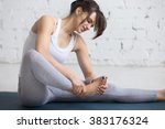 Beautiful young woman feeling pain in her foot during sport workout indoors, close-up,  focus on hands