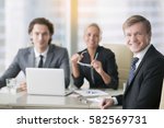 Business people, smiling, successful business partnership, discussing logo, website design, contract, negotiation room for rent. Portrait of mid aged businessman with subordinates at the background 