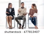 Small photo of Male and female ambitious job seekers waiting for interview, looking at each other with hate and dislike, feeling jealous envious, rivalry and internal competition, get position and sidestep rivals