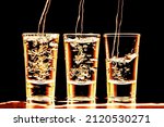 Small photo of Vodka shots in a row. Neon bar encounter. Illuminated transparent glass. Pouring liquor. Weekend party alcohol background. Golden color vodka party.