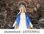 Small photo of Statue of Virgin Mary with stars aureole. Mother Marry in stone cave. Open arms love. Religious background. Catholic religion holy person.