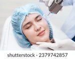 Small photo of Side view of Asian woman getting resurfacing laser fraxel dual and ultrasound face treatment in medical spa center. skin care after treatment, skin rejuvenation concept