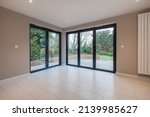 Small photo of Suffolk, England - December 16 2016: Unfurnished modern interior with corner bifold patio folding doors.