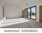 Small photo of Hardwick, Cambridgeshire, England - October 26 2018: Contemporary modern unfurnished bedroom with sloping windows and bifold doors to balcony