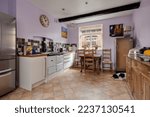 Small photo of Newmarket, Suffolk, England - May 29 2018: Refitted kitchen incorporating modern cabinets, traditional aga and sleeping dog