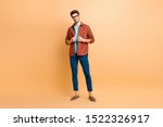 Small photo of Full length body size view of his he nice attractive lovely fashionable brunet guy dandy fixing clothing shirt posing new cool modern look isolated over beige color pastel background
