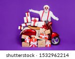 Merry christmas! Photo of fat santa man with many newyear giftboxes on bike congratulating children wear sun specs and red x-mas costume isolated purple background