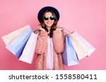 Photo of pretty millennial model lady carry many packs shopper enjoy tourism abroad sales wear fluffy jacket sun specs vintage blue hat isolated pink background