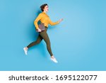 Full length photo of beautiful pretty business lady jump high hold notebook rushing conference wear yellow shirt green pants shoes isolated bright blue color background