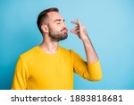 Photo portrait of guy with pouted lips showing gourmet sign with fingers tasty delicious isolated on vibrant blue color background