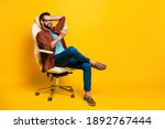 Small photo of Full length body photo of smiling freelancer keeping smartphone social media sitting in chair pause isolated vibrant yellow color background