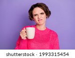 Photo of young girl displeased unhappy grimacing bad smell hold cup of tea isolated over purple color background