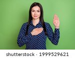 Small photo of Photo of charming serious young woman hold hand chest heart make oath isolated on green color background
