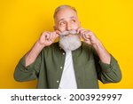 Photo portrait of senior man touching mustache looking dreamy empty space isolated vibrant yellow color background