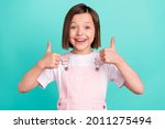 Photo of cheerful happy young small girl make fingers thumbs up smile recommend isolated on teal color background