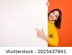 Photo of young woman happy positive smile point finger empty space billboard ad advice choice isolated over orange color background
