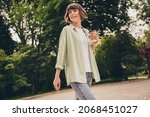 Small photo of Portrait of attractive cheery dreamy girl drinking hot latte beverage resting strolling pastime on fresh air outdoors