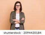Photo of self-assured freelancer lady crossed arms wear eyeglasses khaki shirt isolated beige color background