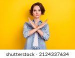 Photo of young pretty serious woman crossed hands show no stop forbidden symbol isolated over yellow color background