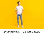 Full body photo of cute young brunet guy stand look ad wear eyewear t-shirt jeans sneakers isolated on yellow background