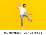 Small photo of Full body photo of cool young brunet guy dance wear eyewear t-shirt jeans footwear isolated on yellow background