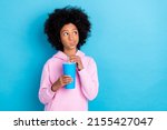 Small photo of Photo of young girl look empty space curious unsure think drink cola isolated over blue color background