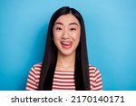 Portrait of charming cheerful indonesian girl tongue lick teeth isolated on blue color background