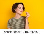 Small photo of Closeup photo of young smiling sniff girl showing cool aroma like buy parfume isolated on yellow color background