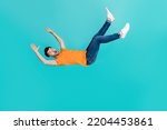 Small photo of Full size photo of frightened guy falling downward by accident isolated on cyan color background