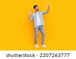 Full length photo of cheery handsome latin man take selfie video call blogger dressed trendy denim look isolated on yellow color background