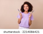 Photo of funky thoughtful lady wear violet t-shirt rising fork knife looking empty space isolated beige color background