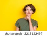 Small photo of Portrait of nice cute woman with bob hairdo dressed khaki t-shirt look empty space finger on chin isolated on yellow color background