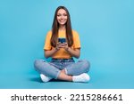 Photo of funny cute girl dressed yellow t-shirt chatting instagram twitter facebook telegram empty space isolated blue color background