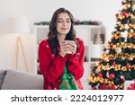 Photo of nice christmas atmosphere woman wear red ugly sweater hold cup of hot tea smells tasty stay home comfortable atmosphere indoors