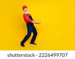 Small photo of Photo of good mood funky senior guy dressed uniform overall red hardhat holding arms heave empty space isolated yellow color background