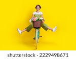 Small photo of Full size photo of nice young girl driving cycle fast hurry scream energetic wear trendy khaki clothes isolated on yellow color background