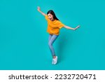 Full body photo of funky brunette lady dance look down wear t-shirt jeans boots isolated on teal color background
