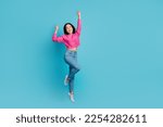 Full length photo of pretty lucky lady wear pink pullover rising fists jumping high empty space isolated blue color background
