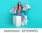 Small photo of Full body cadre of sit white platform girl raise hands up hold much packages with brand clothes shopaholic isolated on aquamarine color background