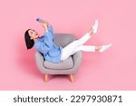 Small photo of Full size portrait of pretty girl sit chair hold use smart phone chatting isolated on pink color background