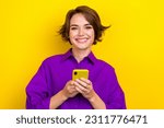 Small photo of Photo of young business entrepreneur woman purple shirt bob brown hair hold phone read fresh news happy isolated on yellow color background
