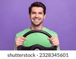 Small photo of Portrait of satisfied cheerful guy with bristle wear green t-shirt holding steering wheel driving car isolated on violet color background