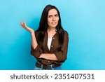 Small photo of Photo of unsatisfied young woman wear brown shirt confused wtf misunderstanding irritated pretense isolated on blue color background